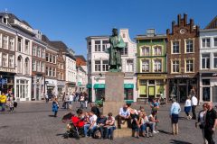 Standbeeld van de beroemde schilder Jeroen Bosch op de Markt in Den Bosch, met 'De Kleine Winst', het huis waar Bosch opgroeide en dat nu net museum "Huis van Bosch' huisvest © www.hollandfoto.net - Shutterstock.com