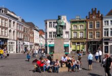 Standbeeld van de beroemde schilder Jeroen Bosch op de Markt in Den Bosch, met 'De Kleine Winst', het huis waar Bosch opgroeide en dat nu net museum "Huis van Bosch' huisvest © www.hollandfoto.net - Shutterstock.com