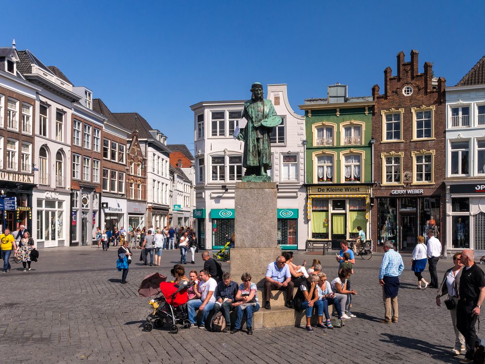 Standbeeld van de beroemde schilder Jeroen Bosch op de Markt in Den Bosch, met 'De Kleine Winst', het huis waar Bosch opgroeide en dat nu net museum "Huis van Bosch' huisvest © www.hollandfoto.net - Shutterstock.com