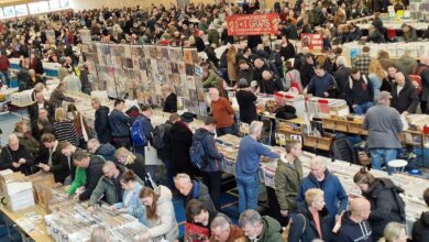 Bezoekers bekijken vinylplaten en lp’s tijdens een grote platenbeurs