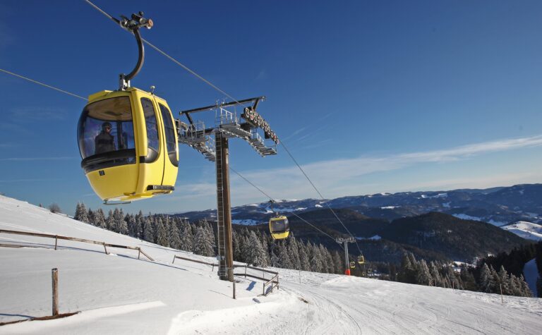 Wintersporters op een besneeuwde piste in de Alpen, waar skivakanties de afgelopen vier jaar duurder zijn geworden